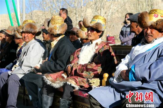 西藏阿里地区独特的自然风光及具有深厚文化底蕴和举世闻名的人文景观，吸引着越来越多的游客走进阿里，旅游业也让当地民众得到越来越多的实惠。资料图：阿里地区札达县民众在扶贫搬迁仪式上。札达县委宣传部供
