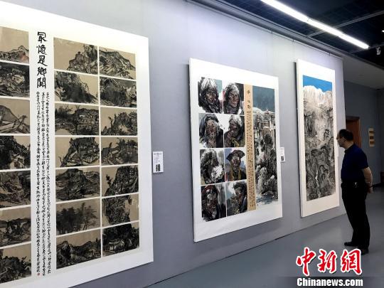 图为民众观看展出的作品。　崔佳明 摄